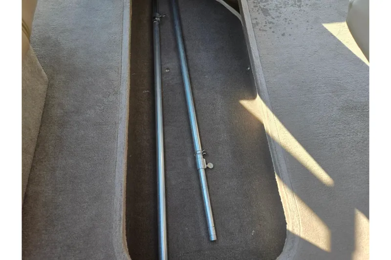 Slide: The Image of 1998 Regal Valanti 176 interior storage compartment with metal poles on carpeted floor. - 12