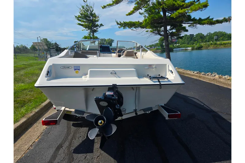 Slide: The Image of 1998 Regal Valanti 176 boat on trailer by a lakeside road. - 2