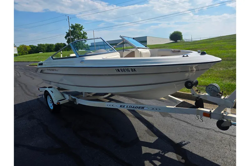 Slide: The Image of 1998 Regal Valanti 176 boat on trailer, parked outdoors under a clear sky. - 5
