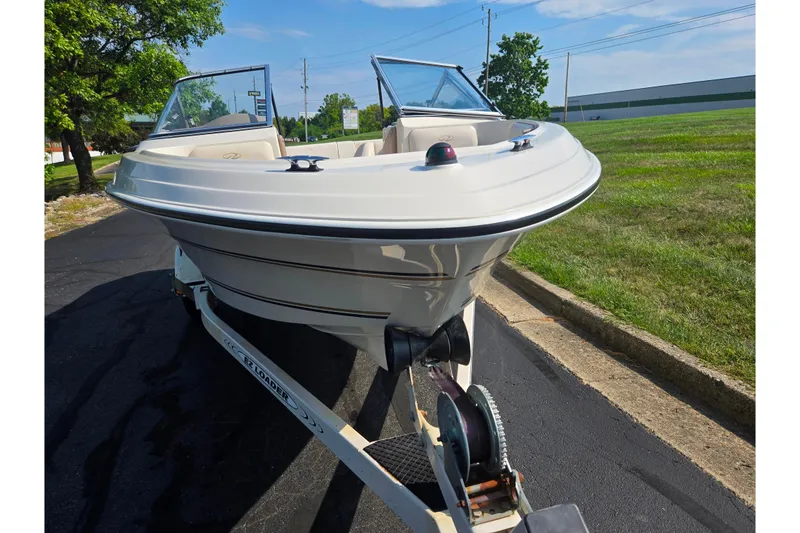 Slide: The Image of 1998 Regal Valanti 176 boat on trailer, parked on asphalt near grassy area. - 6