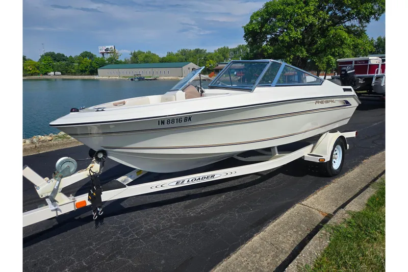 Slide: The Image of 1998 Regal Valanti 176 boat on trailer by a lakeside, sunny day. - 8