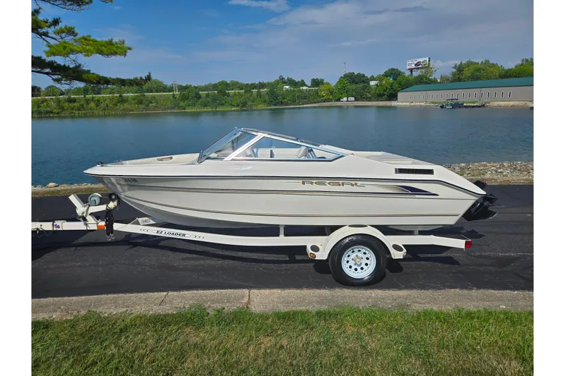 Slide: The Image of 1998 Regal Valanti 176 boat on trailer by a scenic lake. - 9