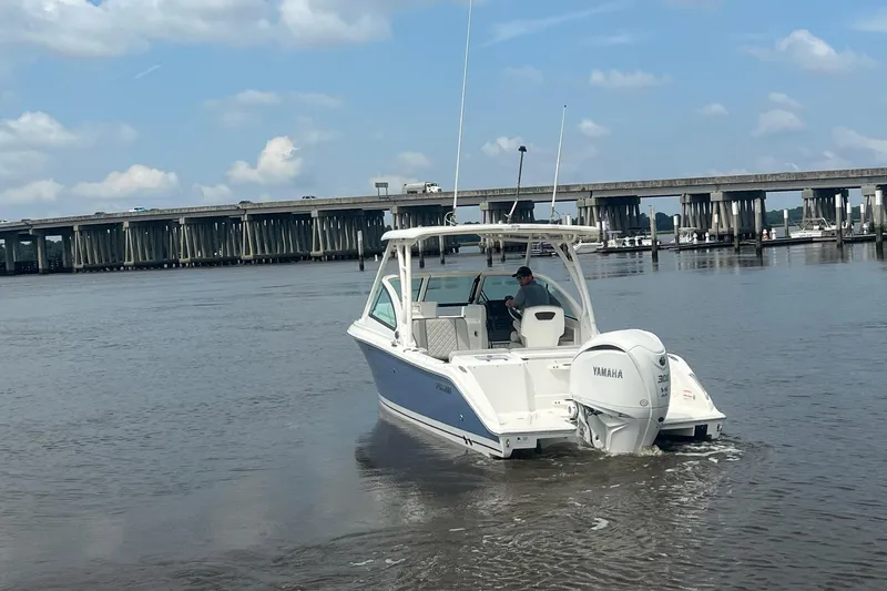 Slide: The Image of 2023 Pursuit DC 246 Dual Console boat on water near a bridge, featuring Yamaha engine. - 11