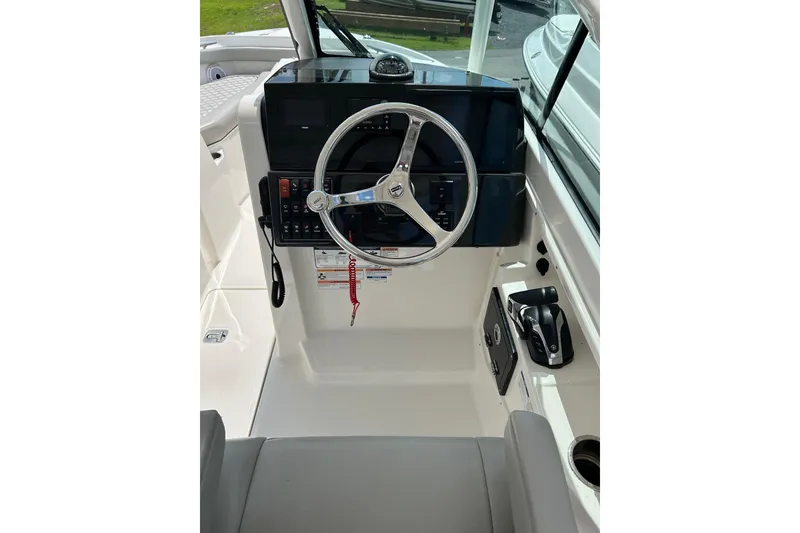 Slide: The Image of 2023 Pursuit DC 246 Dual Console boat helm with steering wheel and controls. - 3