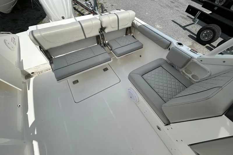 Slide: The Image of 2023 Pursuit DC 246 Dual Console boat interior with cushioned seating and storage. - 4