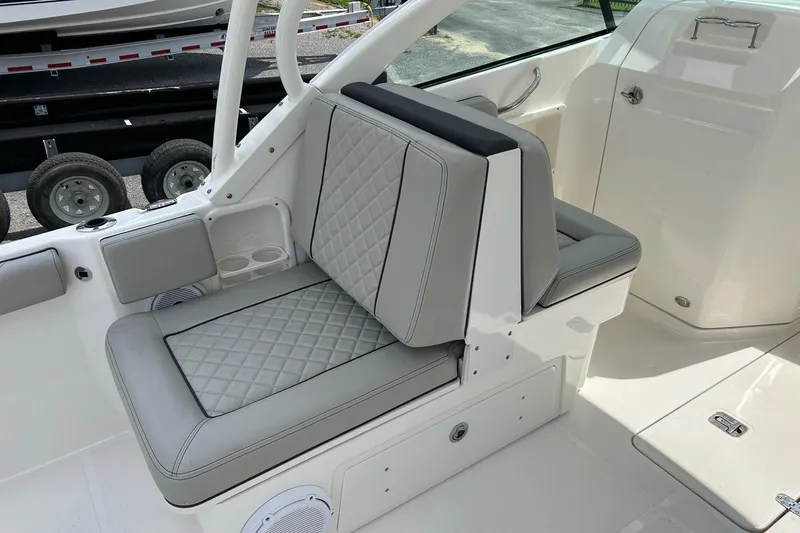 Slide: The Image of 2023 Pursuit DC 246 Dual Console boat interior with gray quilted seating. - 5