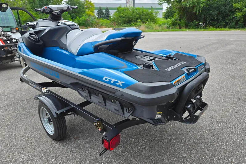 Slide: The Image of 2019 Sea-Doo GTX 230 jet ski on trailer, blue and black design, parked outdoors. - 3