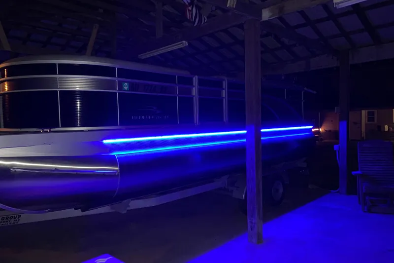 Slide: The Image of 2021 Bennington SX21 pontoon boat with blue LED lights in a covered dock. - 10