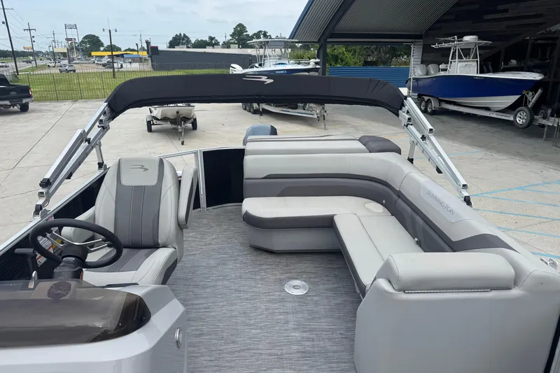 Slide: The Image of 2021 Bennington SX21 pontoon boat with spacious seating and canopy in a marina setting. - 14