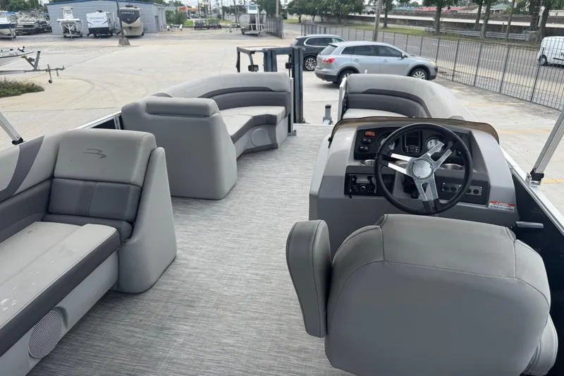 Slide: The Image of 2021 Bennington SX21 pontoon boat interior with gray seating and steering console. - 6