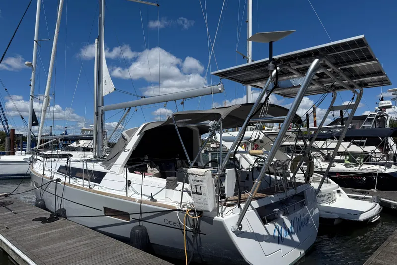 Slide: The Image of 2013 Beneteau Oceanis 41 sailboat docked, featuring solar panels and clear blue sky. - 12