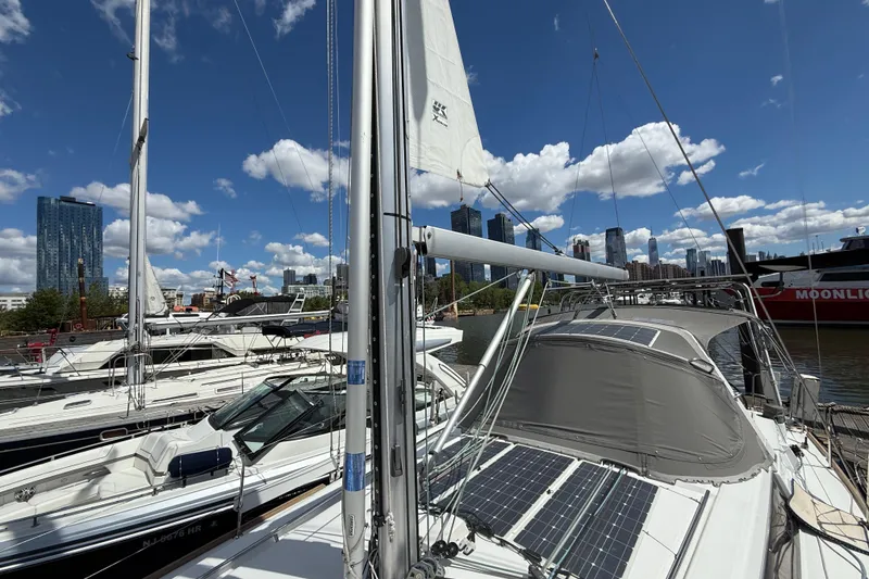 Slide: The Image of 2013 Beneteau Oceanis 41 sailboat docked in urban marina, city skyline in background. - 15