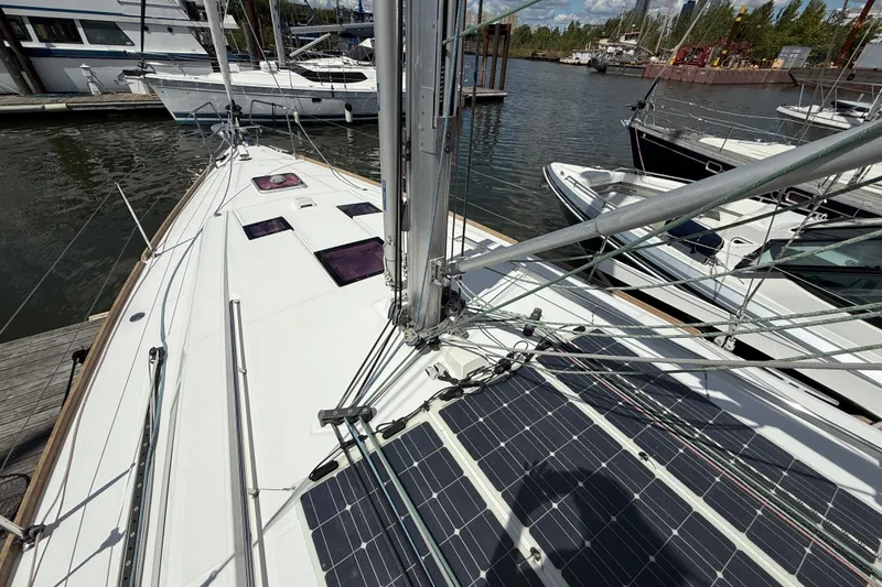 Slide: The Image of 2013 Beneteau Oceanis 41 sailboat docked, featuring solar panels and rigging. - 24