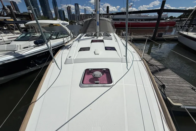 Slide: The Image of 2013 Beneteau Oceanis 41 sailboat docked at marina with city skyline backdrop. - 27