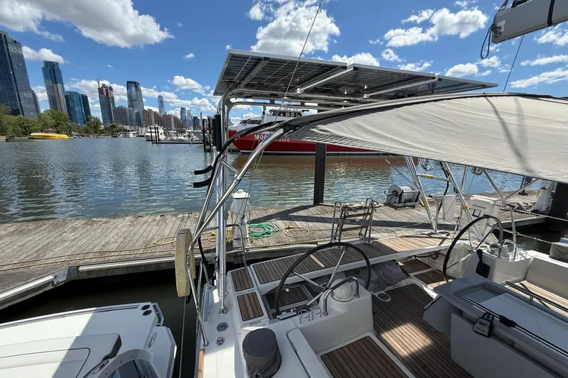 Slide: The Image of Beneteau Oceanis 41 sailboat docked at marina, city skyline in background, sunny day. - 29
