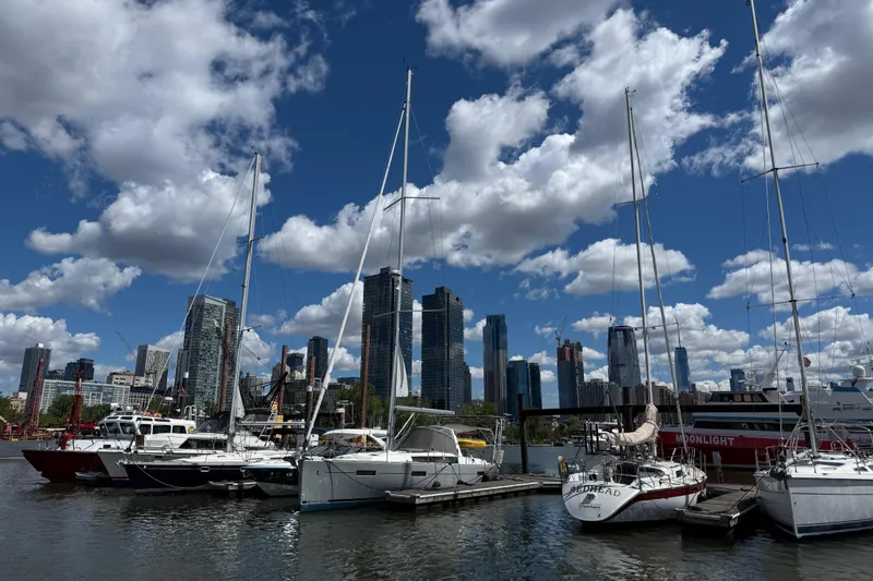 Slide: The Image of Sailboats docked at a marina with city skyline, featuring a 2013 Beneteau Oceanis 41. - 5