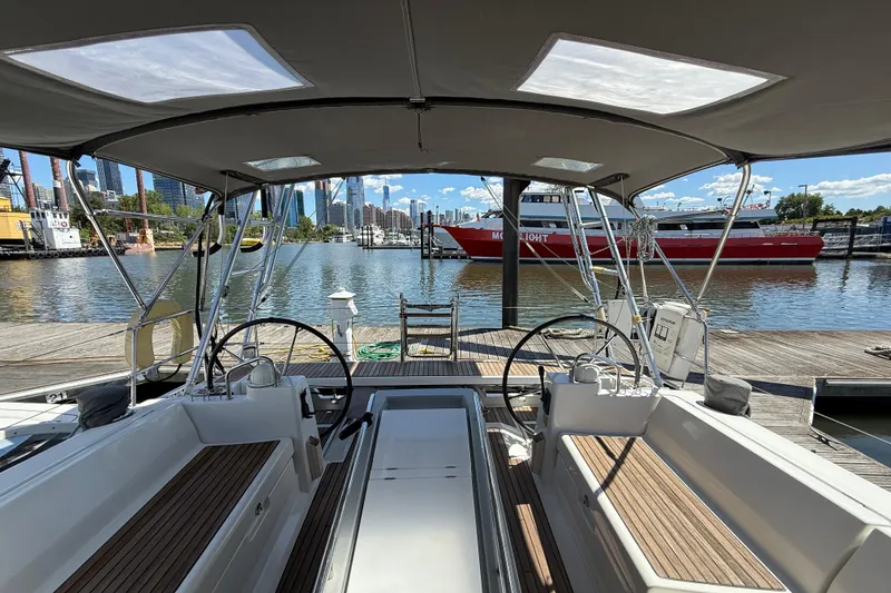 Slide: The Image of 2013 Beneteau Oceanis 41 sailboat docked at marina with city skyline view. - 53