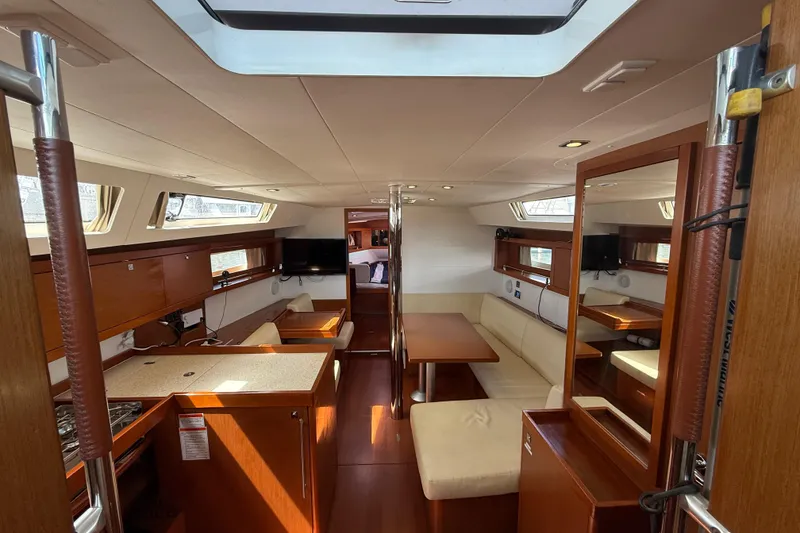 Slide: The Image of Interior of 2013 Beneteau Oceanis 41 yacht, featuring elegant wood finishes and spacious seating. - 54