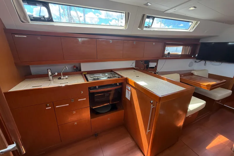 Slide: The Image of Interior of 2013 Beneteau Oceanis 41 yacht, featuring a modern kitchen and dining area. - 56