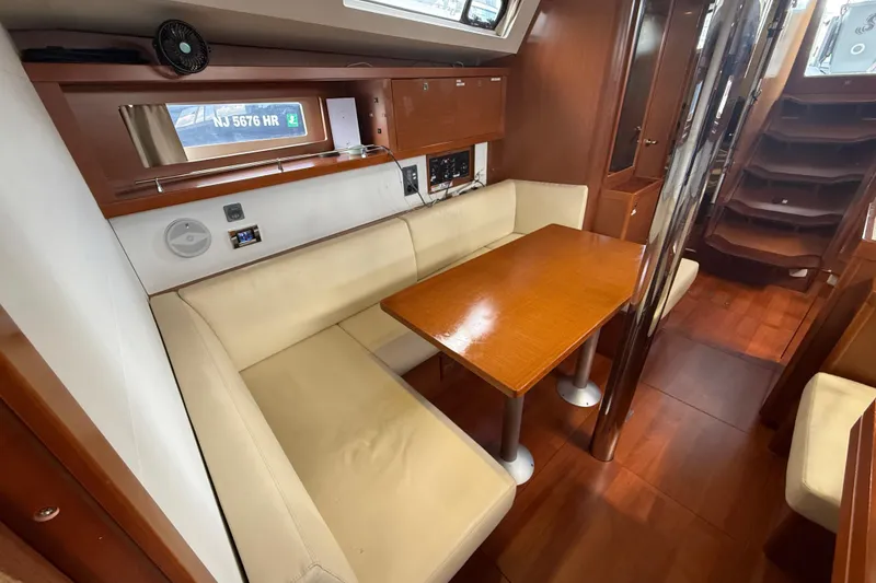 Slide: The Image of Interior of 2013 Beneteau Oceanis 41 sailboat with cozy dining area and wooden finishes. - 77