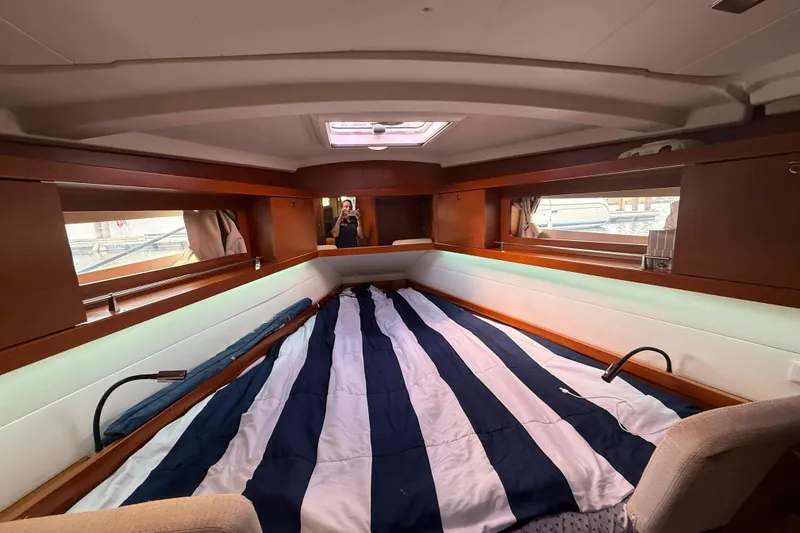 Slide: The Image of Interior cabin of 2013 Beneteau Oceanis 41 sailboat with striped bedding and wood accents. - 84