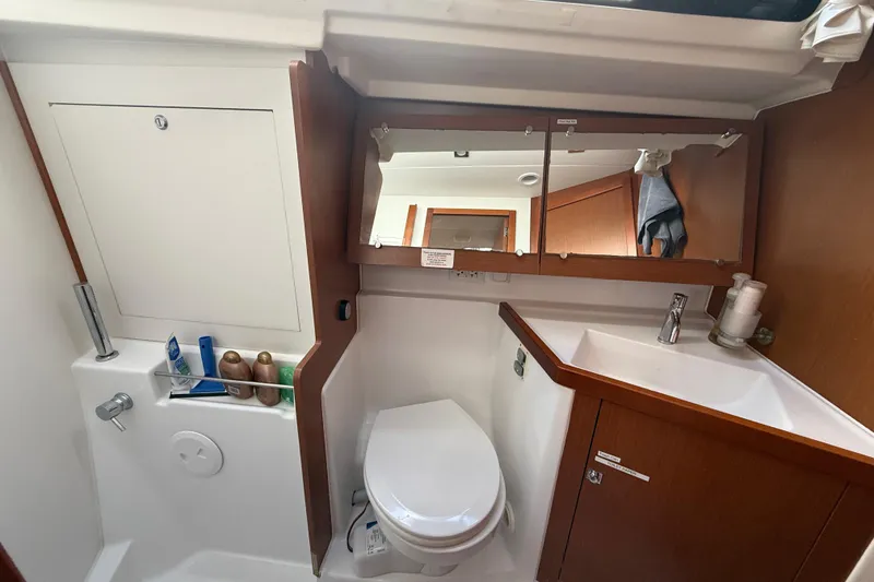 Slide: The Image of Bathroom of 2013 Beneteau Oceanis 41 yacht with sink, toilet, and mirror cabinet. - 95