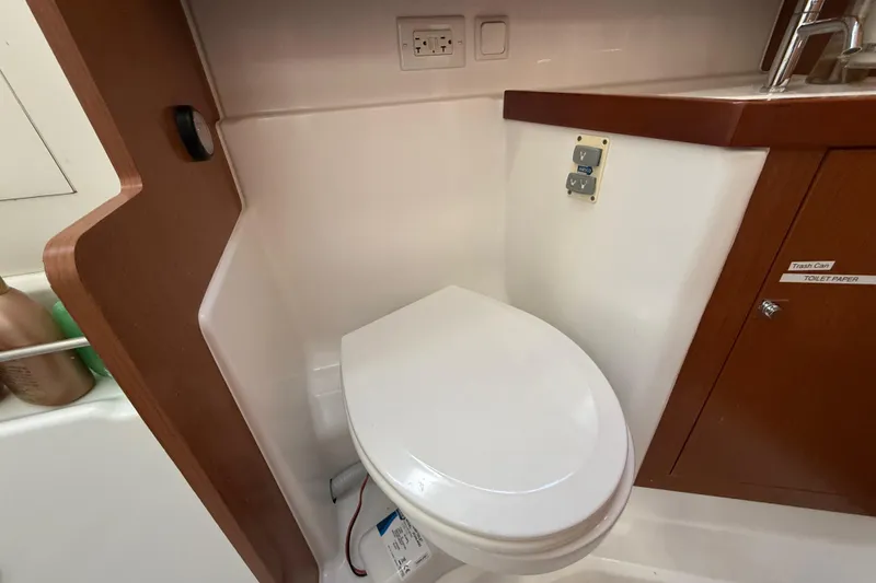 Slide: The Image of Beneteau Oceanis 41 (2013) yacht bathroom with toilet and wooden cabinetry. - 96