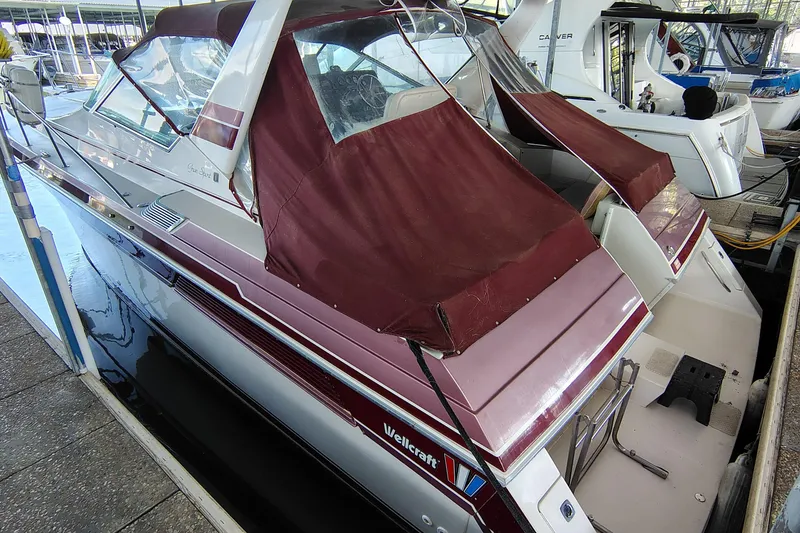 Slide: The Image of 1989 Wellcraft Gran Sport 3400 boat docked with maroon covers and sleek design. - 10