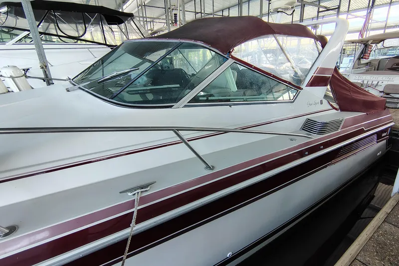 Slide: The Image of 1989 Wellcraft Gran Sport 3400 boat with maroon accents docked in a marina. - 11