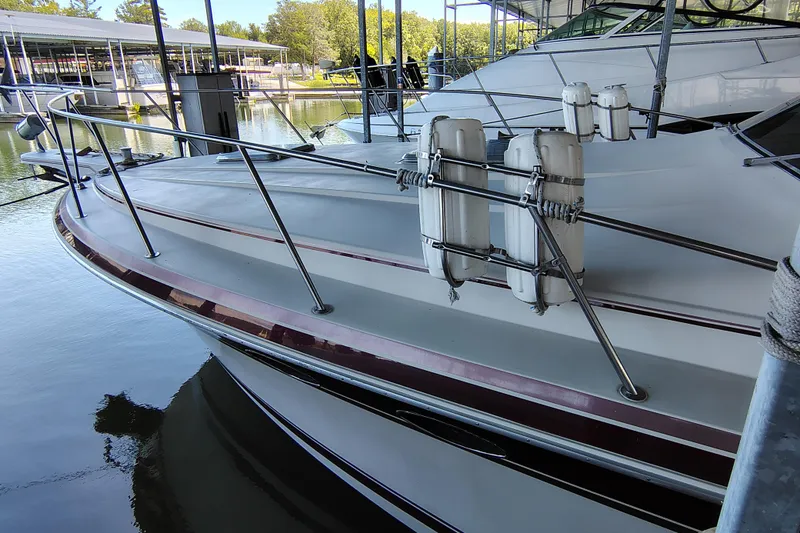 Slide: The Image of 1989 Wellcraft Gran Sport 3400 boat docked with fenders, reflecting on calm water. - 12