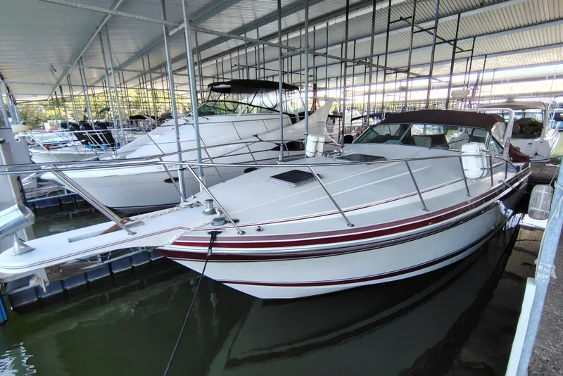 Slide: The Image of 1989 Wellcraft Gran Sport 3400 boat docked in a covered marina. - 13