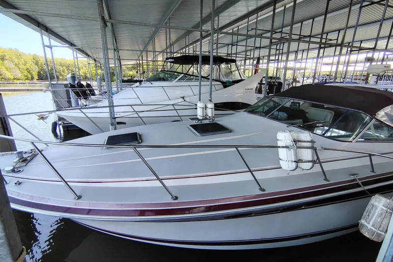 Slide: The Image of 1989 Wellcraft Gran Sport 3400 docked in a covered marina, alongside other boats. - 15