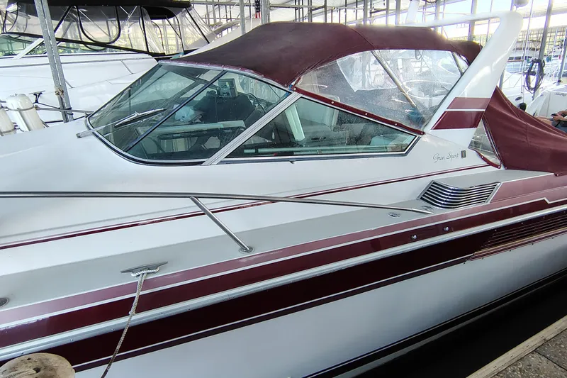 Slide: The Image of 1989 Wellcraft Gran Sport 3400 boat with maroon accents docked in a marina. - 16