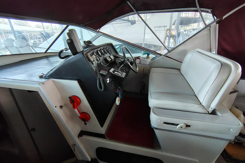 Slide: The Image of 1989 Wellcraft Gran Sport 3400 boat cockpit with steering wheel and white seating. - 22