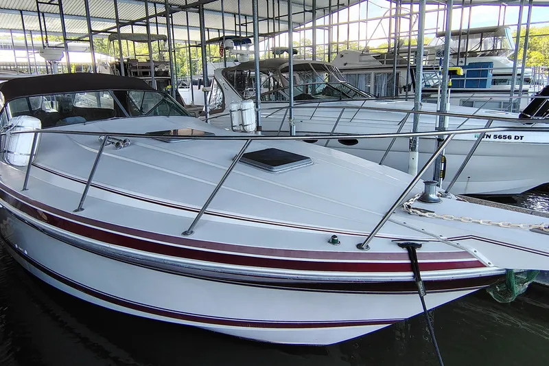 Slide: The Image of 1989 Wellcraft Gran Sport 3400 boat docked in a marina, featuring sleek design and white hull. - 3
