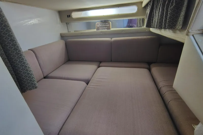 Slide: The Image of Interior cabin of 1989 Wellcraft Gran Sport 3400 with cushioned seating and curtains. - 37