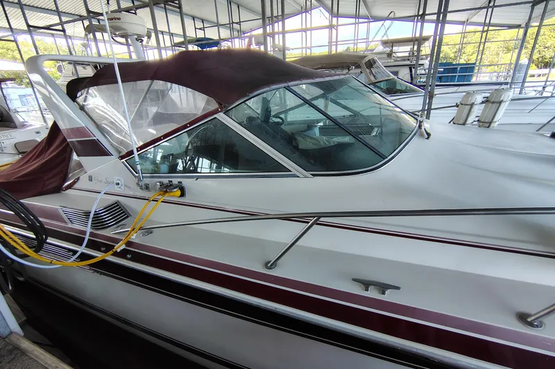 Slide: The Image of 1989 Wellcraft Gran Sport 3400 boat docked under a covered marina. - 5