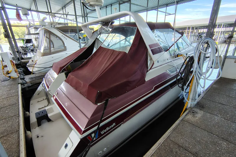 Slide: The Image of 1989 Wellcraft Gran Sport 3400 boat docked with maroon cover in marina. - 6