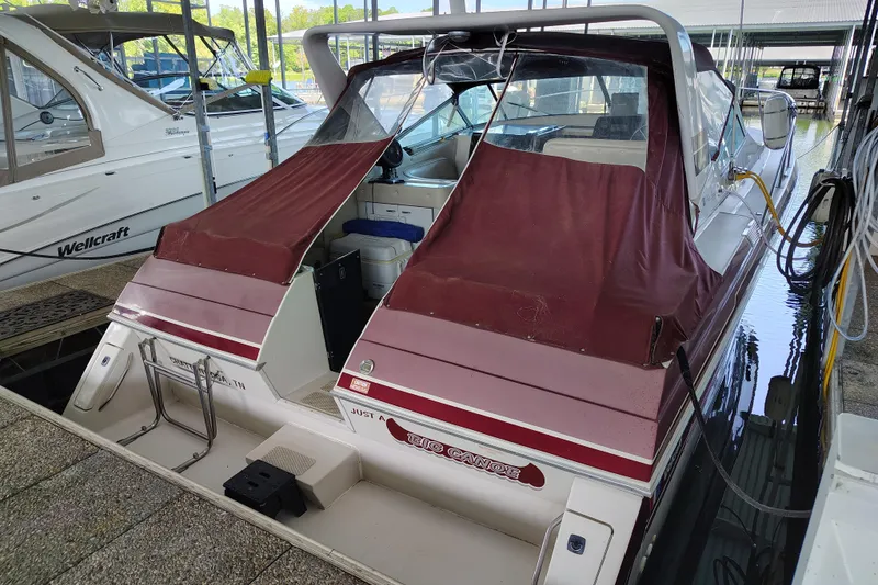 Slide: The Image of 1989 Wellcraft Gran Sport 3400 boat docked with maroon cover, rear view. - 7