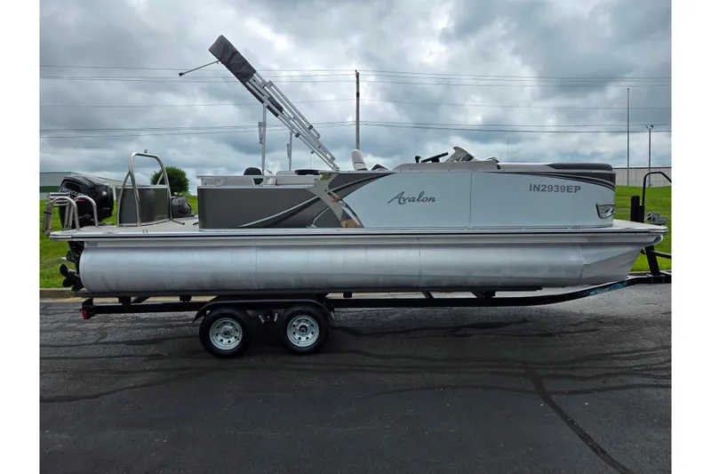 Slide: The Image of 2024 Avalon LSZ Cruise Bench pontoon boat on trailer, overcast sky background. - 4