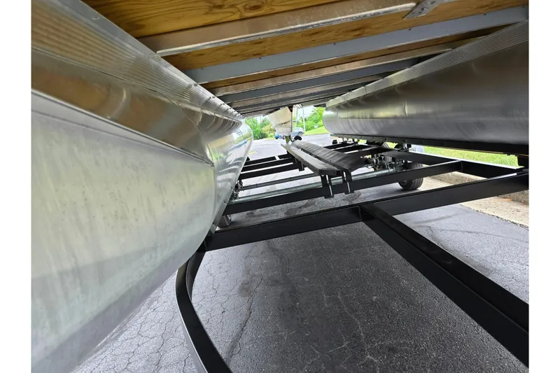 Slide: The Image of Underneath view of 2024 Avalon LSZ Cruise Bench pontoon on a trailer. - 7