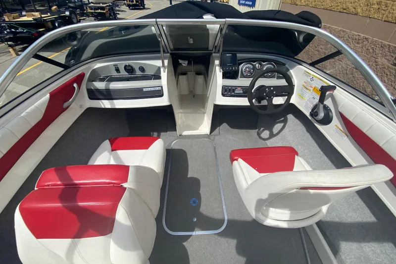 Slide: The Image of 2013 Bayliner 185 Bowrider interior with red and white seating, steering wheel, and dashboard controls. - 6