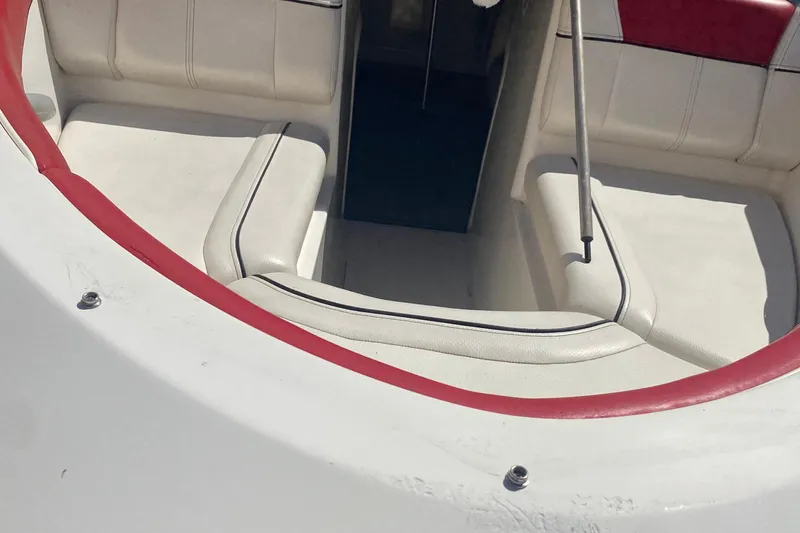 Slide: The Image of 2013 Bayliner 185 Bowrider interior with white seating and red trim. - 7