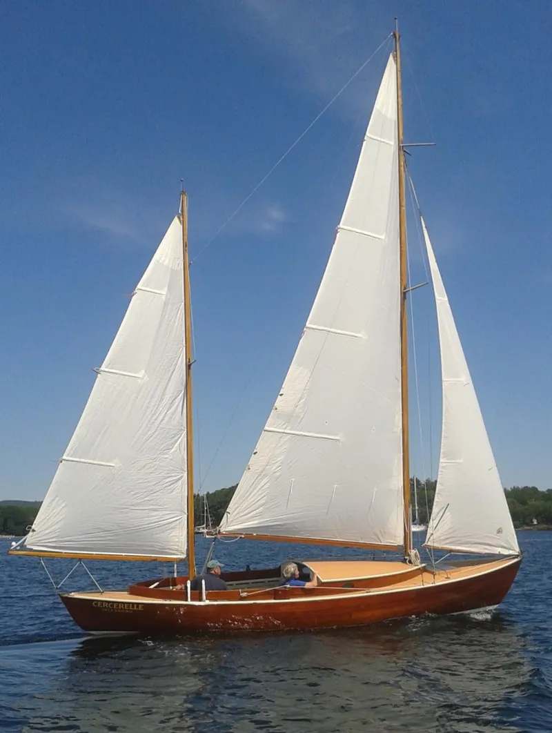 Slide: The Image of 1972 Herreshoff Rozinante sailboat on calm water under clear blue sky. - 13