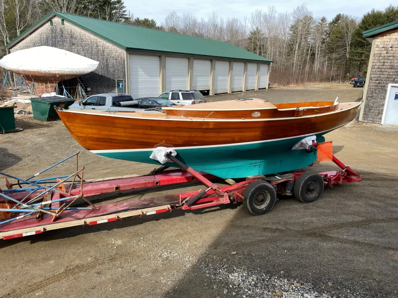 Slide: The Image of 1972 Herreshoff Rozinante sailboat on trailer, wooden hull, green bottom, outdoor storage area. - 16