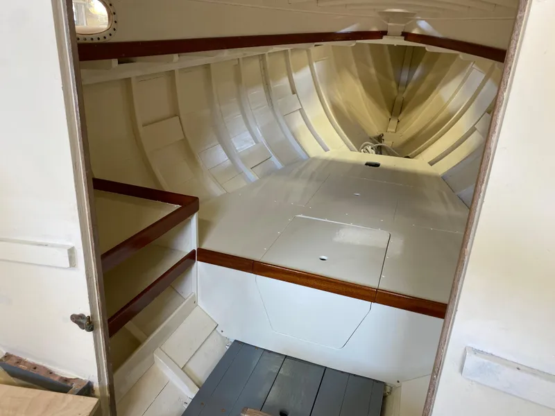 Slide: The Image of Interior of 1972 Herreshoff Rozinante sailboat, showcasing wooden and white paneling. - 17