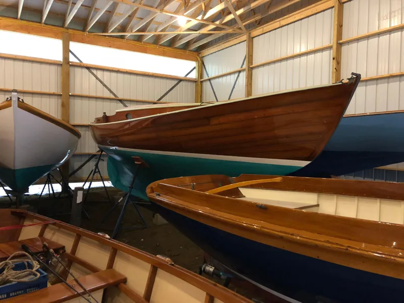 Slide: The Image of 1972 Herreshoff Rozinante sailboat in a wooden boat storage facility. - 4