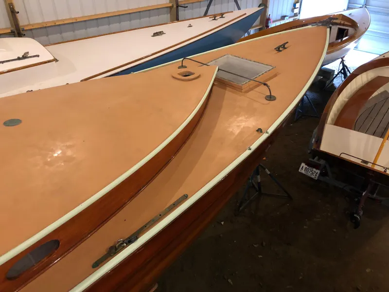 Slide: The Image of 1972 Herreshoff Rozinante sailboat in storage, showcasing sleek wooden deck design. - 8