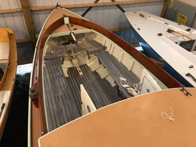 Slide: The Image of 1972 Herreshoff Rozinante sailboat with wooden interior, stored indoors. - 9