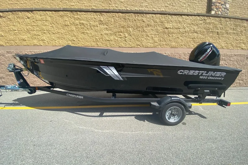 Slide: The Image of 2023 Crestliner 1650 Discovery SC boat on trailer, covered and parked outdoors. - 1